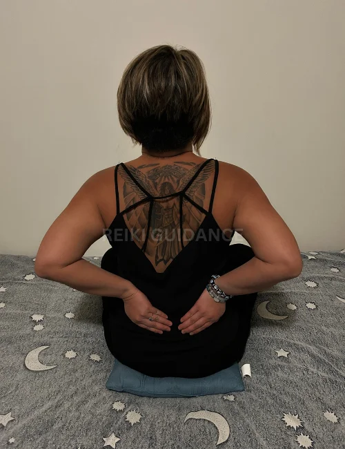 Woman with hands over the kidneys, an essential Reiki self-healing position