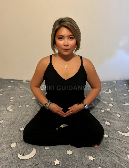 Woman with hands over the sacral chakra, an essential Reiki self-healing position